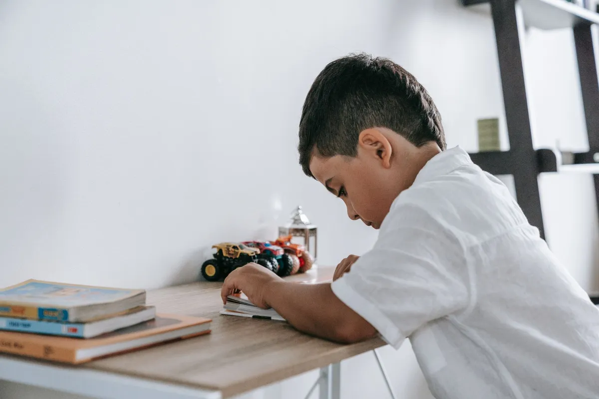 Anak mengerjakan PR di meja belajar